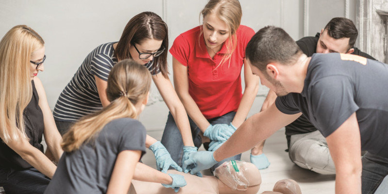 The picture shows a group of three women and two men during a first aid exercise. 