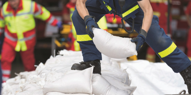 The picture shows emergency workers stacking sandbags.