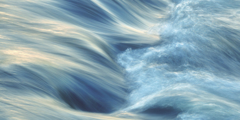 The picture shows a stream of water shooting down a rapids.