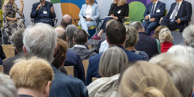 Auf Bühne sitzen die Moderatorin sowie Reiner Haseloff, Ministerpräsident des Landes Sachsen-Anhalt, Steffi Lemke, Dirk Messner, Lilian Busse sowie Robert Reck und haben Fragen des Umwelt- und Klimaschutzes aus verschiedenen Perspektiven beleuchtet.