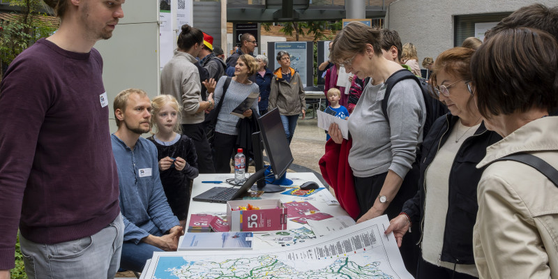 Zu sehen sind viele Personen auf die Bild, die miteinander reden. Interaktive Elemente und wissenschaftliche Präsentationen wurden von den Gästen sehr gut angenommen und sorgten für reges Interesse. 