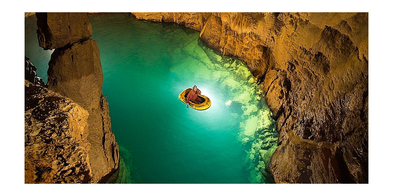 Ein Foto in der Blauhöhle. Zu sehen Grundwasser und eine Person in einem Boot.