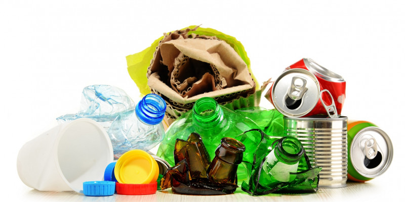 The photo shows packaging waste: Cans, bottles, paper. 