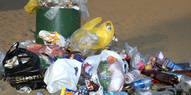 Überquellender Mülleimer am Strand