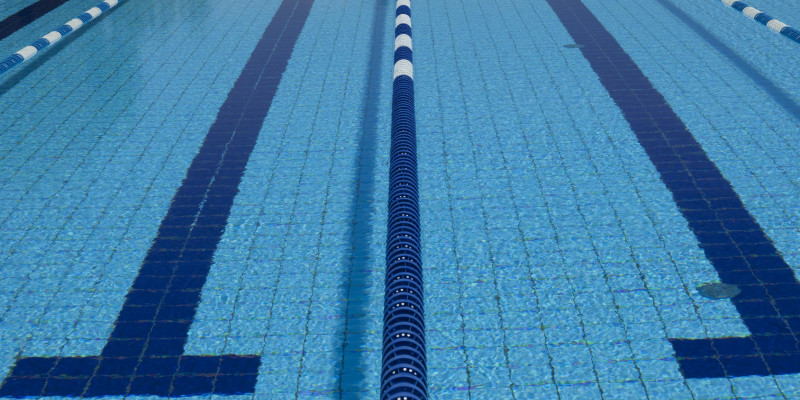 Das Wasserbecken eines Schwimmbades, wo die Bahnen durch schwimmende Abgrenzungen voneinander abgetrennt sind. Nahaufnahme