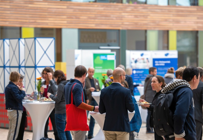 Menschen und Stände im UBA Foyer