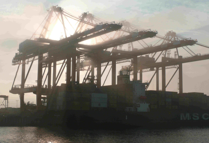 Hafenblick Bremerhaven mit Containerkran und Containerschiff.