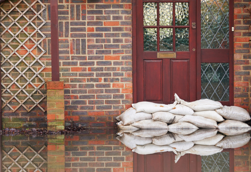 Sandsäcke wurden vor einer Haustür aufgestapelt, um das Haus vor Hochwasser zu schützen