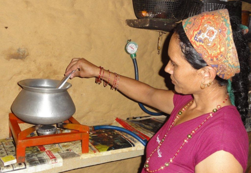 eine Frau in Nepal kocht zuhause auf einem kleinen Gaskocher