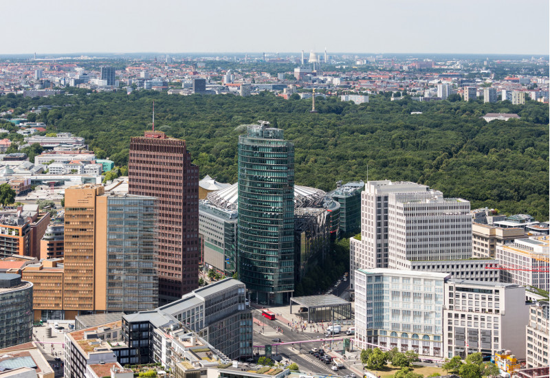 der Potsdamer Platz mitz seinen Hochhäusern und die große waldartige Grünanlage "Großer Tiergarten" in Berlin von oben gesehen