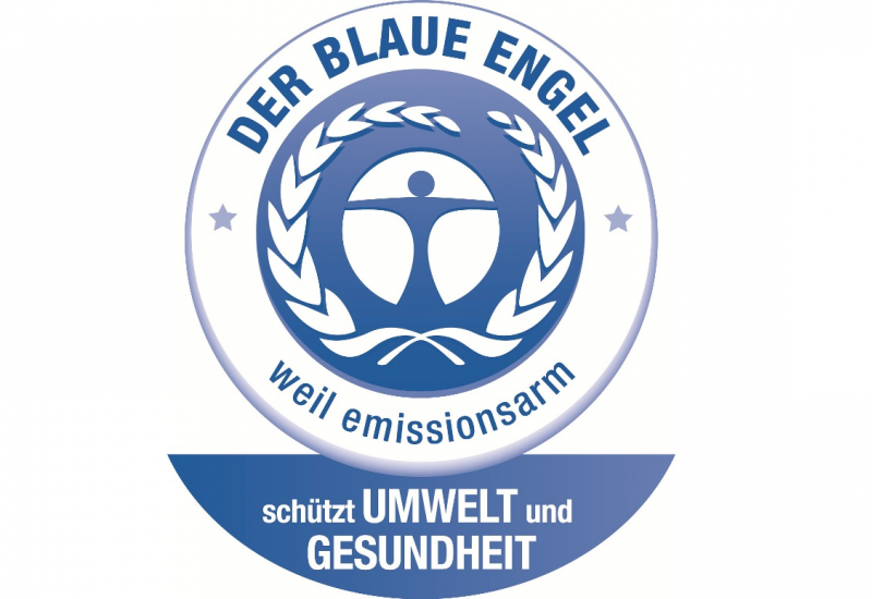 ein stilisierter blauer Mensch in einem weiß-blauen Kreis mit einem beblätterten Zweig und der Aufschrift: Der Blaue Engel - weil emissionsarm - schützt Umwelt und Gesundheit