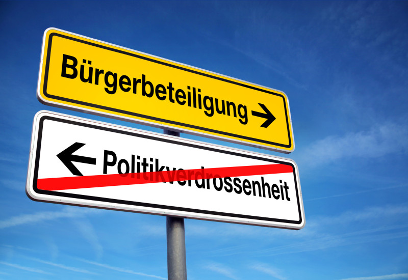 A road sign „Bürgerbeteiligung“ (civic participation) and „Politikverdrossenheit“ (disenchantment with politics)