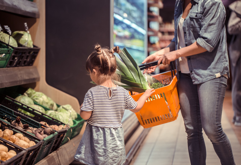 eine Mutter mit ihrer kleinen Tochter beim Einkaufen in einem Supermarkt