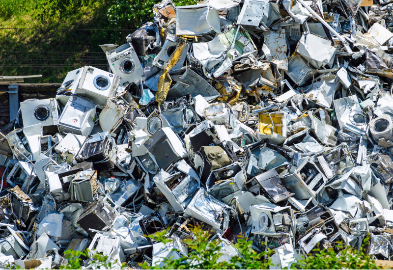 old washing machines pile up at a recycling center