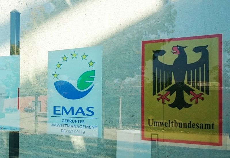 EMAS-Logo an der Glasfassade des Haupteingangs des UBA Dessau-Roßlau