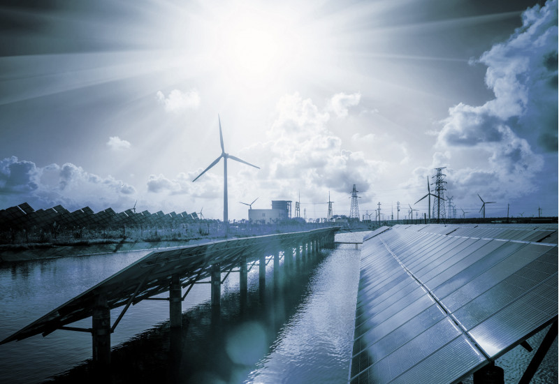 in einer futuristisch anmutenden Szenerie mit blauem Licht stehen Solarpanels auf einer Wasserfläche, im Hintergrund Windkraftanlagen und Strommasten