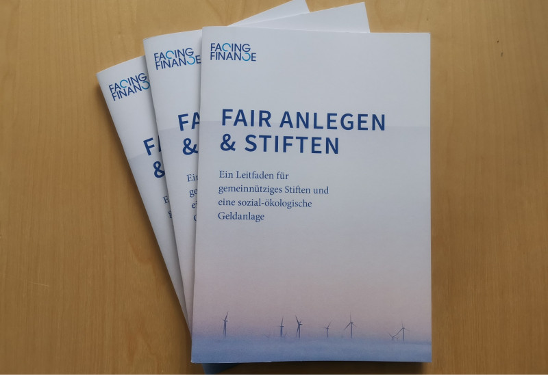 drei Druckversionen des Leitfadens "Fair anlegen & stiften", auf dem Cover sind Windkraftanlagen abgebildet