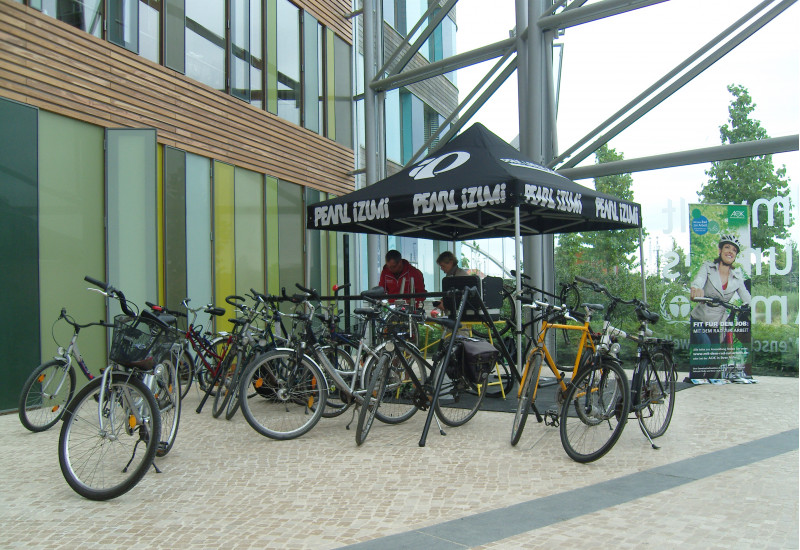 im Eingangsbereich des UBA-Dienstgebäudes Dessau werden Fahrräder repariert, im Hintergrund ein Werbeplakat für die Aktion "Mit dem Rad zur Arbeit"