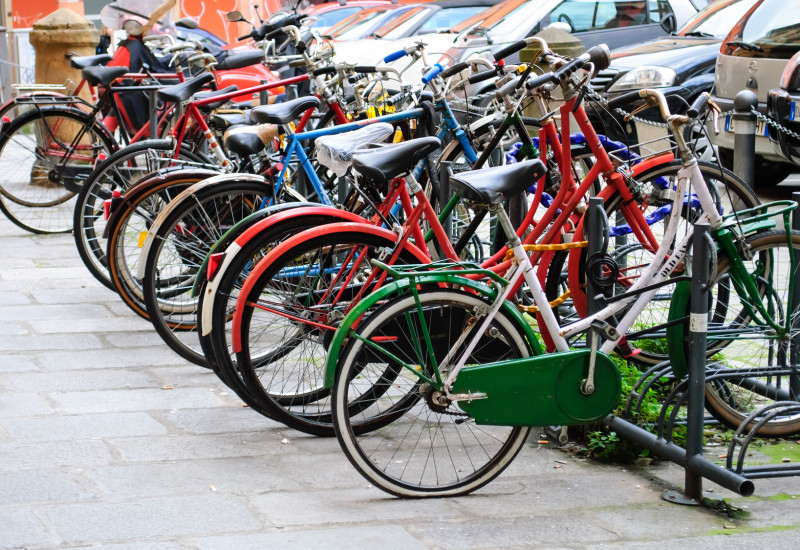 viele bunte Fahrräder in Fahrradständern abgestellt