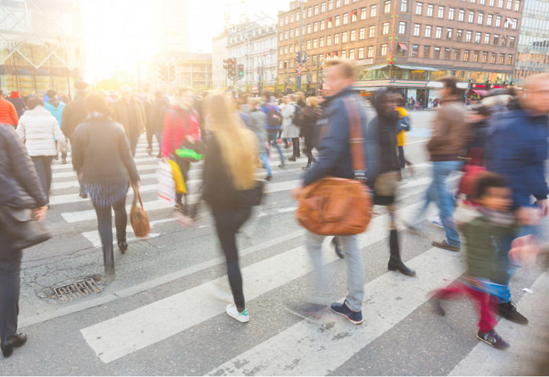viele Menschen in der Stadt gehen über einen Zebrastreifen