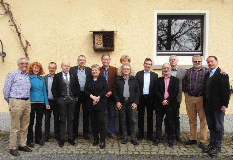 Gruppenfoto mit 10 Männern und 4 Frauen vor einem Gebäude
