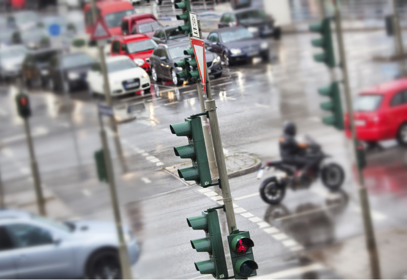 dicht befahrene Straßenkreuzung mit Ampeln, Autos und Motorrad