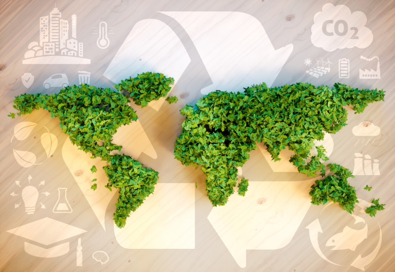 grüne Weltkarte, dahinter ein Symbol für Kreislaufwirtschaft / Recycling