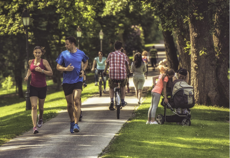 Menschen in einem Stadtpark, die joggen oder spazieren gehen
