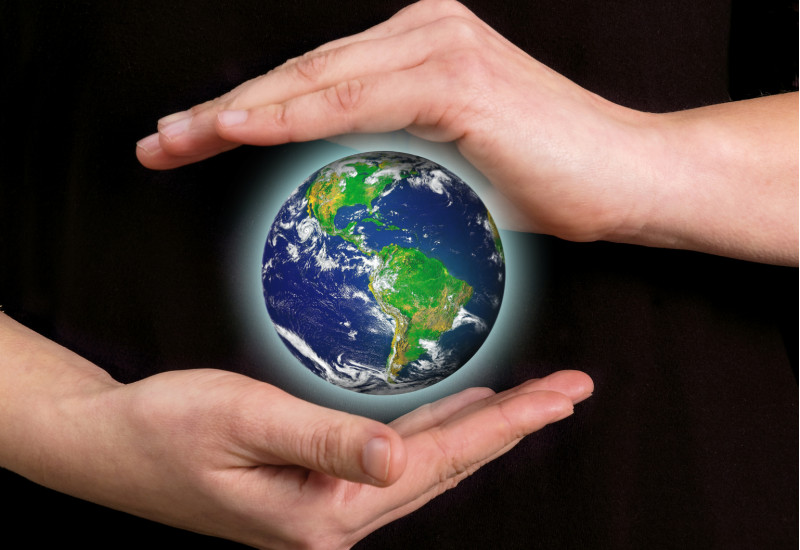 zwei Hände beschützen den Planet Erde