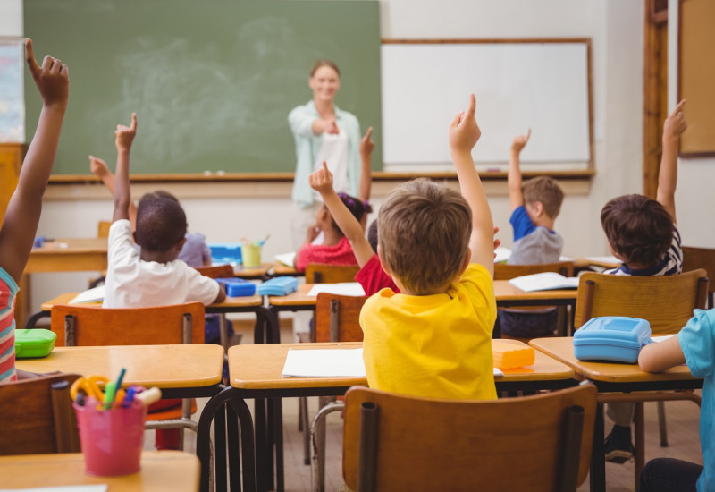 Kinder und Lehrerin im Klassenraum einer Grundschule
