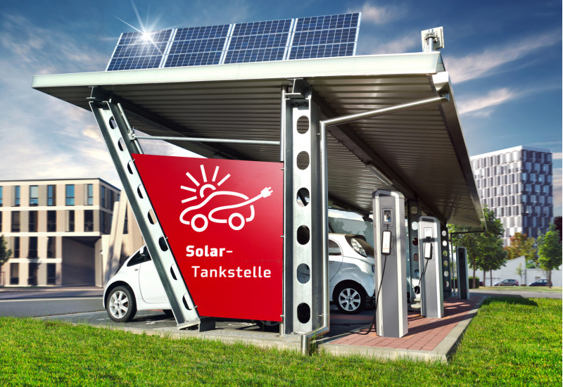 computeranimiertes Bild einer Solartankstelle in der Stadt: auf dem Dach befinden sich Solarmodule, unter dem Dach parken Autos, die Strom tanken