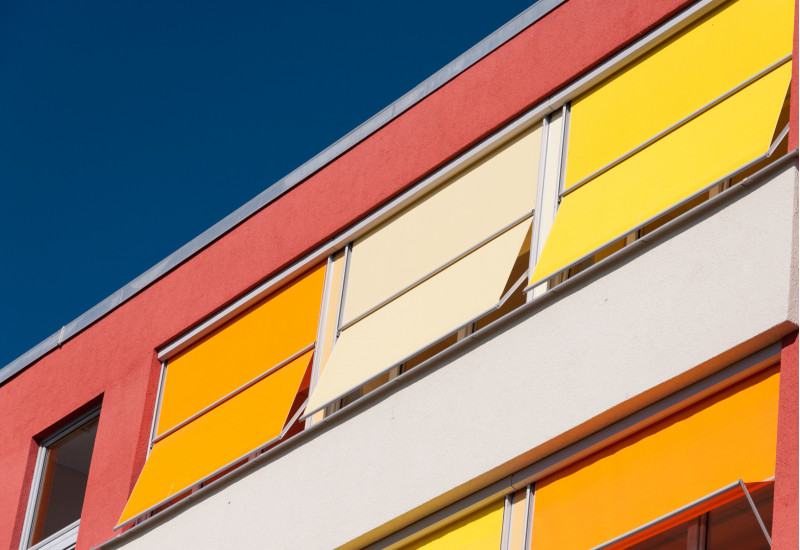 Gebäudefassade mit farbenfrohem Sonnenschutz