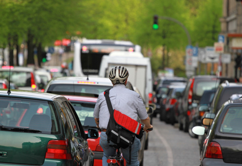 Radfahrer zwischen Autos im Stau