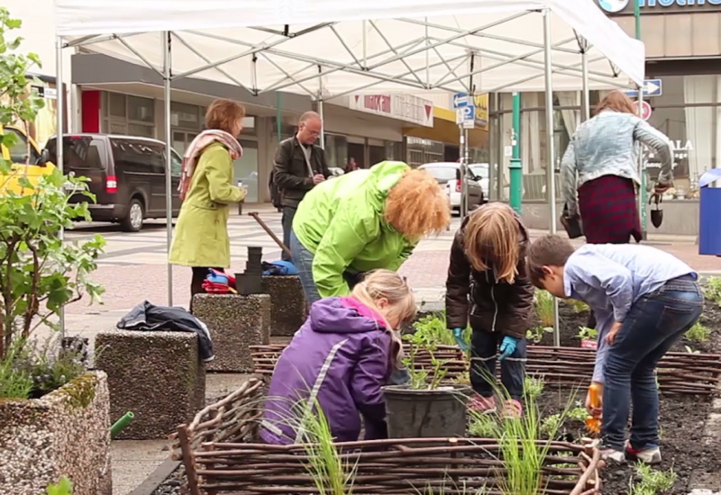 Erwachsene und Kinder bei einer Urban-Gardening-Aktion