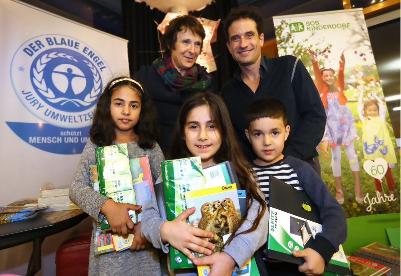 Gruppenfoto: Maria Krautzberger, Oliver Mommsen und drei Kinder mit Kinderheften, Taschentücher-Paketen und anderen Produkten im Arm