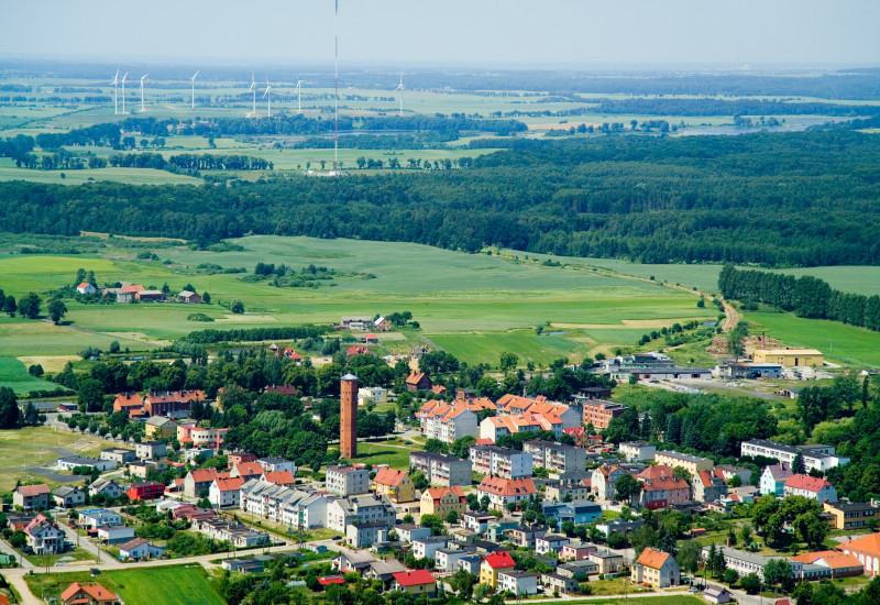 Kleinstadt, in der Ferne sind Windkraftanlagen zu sehen
