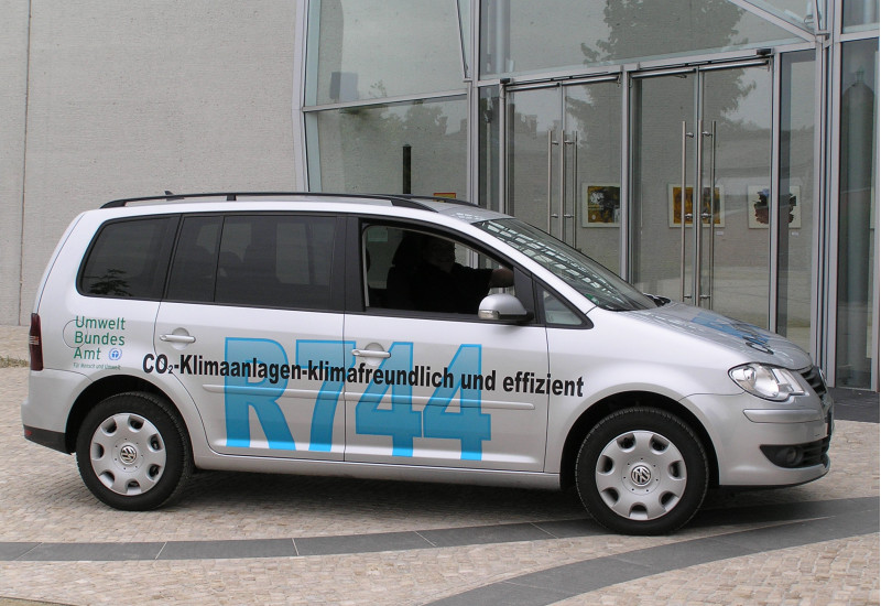 VW-Auto mit der Aufschrift "R744, CO2-Klimaanlagen - klimafreundlich und effizient" und dem Logo des Umweltbundesamtes