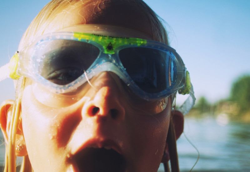 Ein Mädchen schwimmt im offenen Wasser: Sie trägt eine Schwimmbrille.