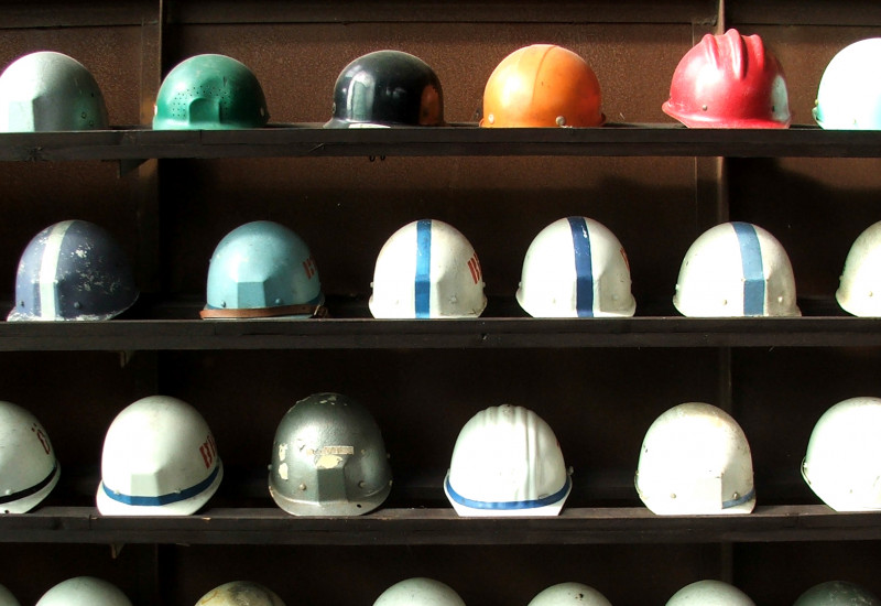 Construction workers' helmets neatly lined up on a shelf