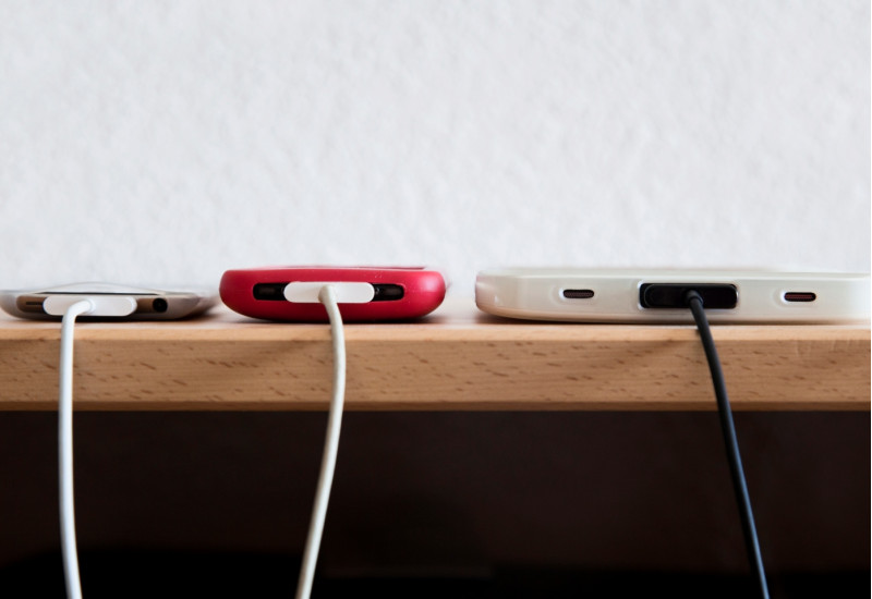 Drei Smartphones am Ladekabel