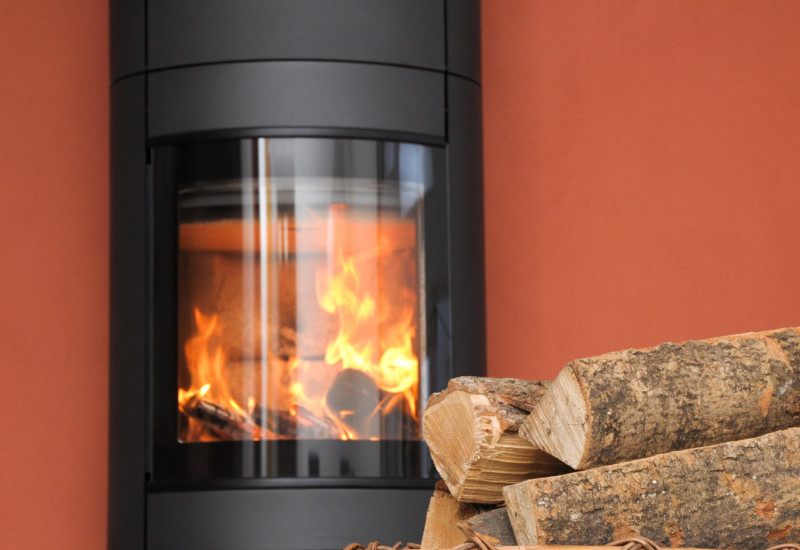 Kaminofen mit Feuer und Brennholzkorb