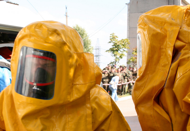 Männer in gelben Plastikanzügen beim Chemikalienunfall