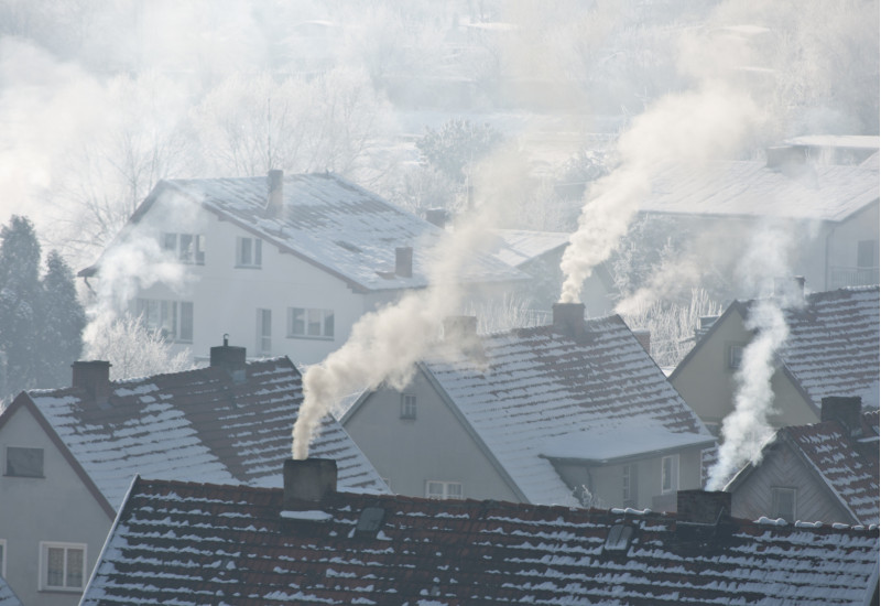 different houses, covered with snow, with smoking chimneys