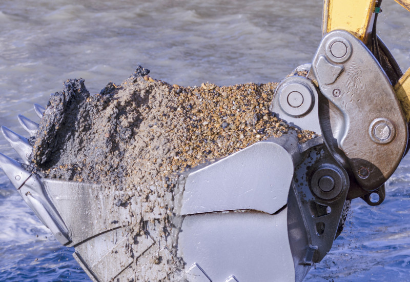 Baggerschaufel mit Sediment aus einem Fluss