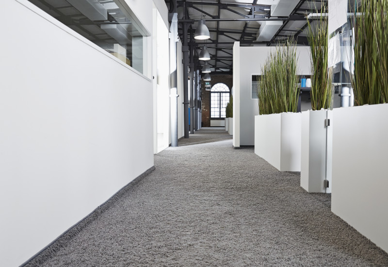 Flur in einem Bürogebäude, der mit einem textilen Bodenbelag ausgestattet ist