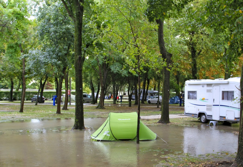 grünes Zelt im Wasser auf überflutetem Campingplatz