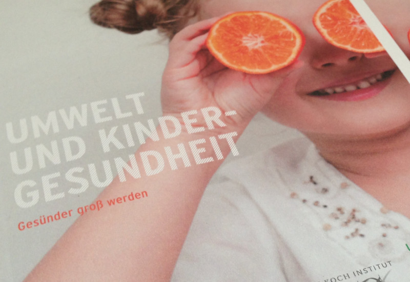 Cover der Broschüre mit einem Foto eines kleinen Mädchens, das sich aus Spaß zwei halbe Orangen vor die Augen hält