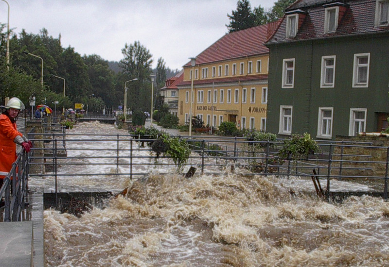 Ein Feuerwehrmann schaut zu wie braune Wassermassen abließen