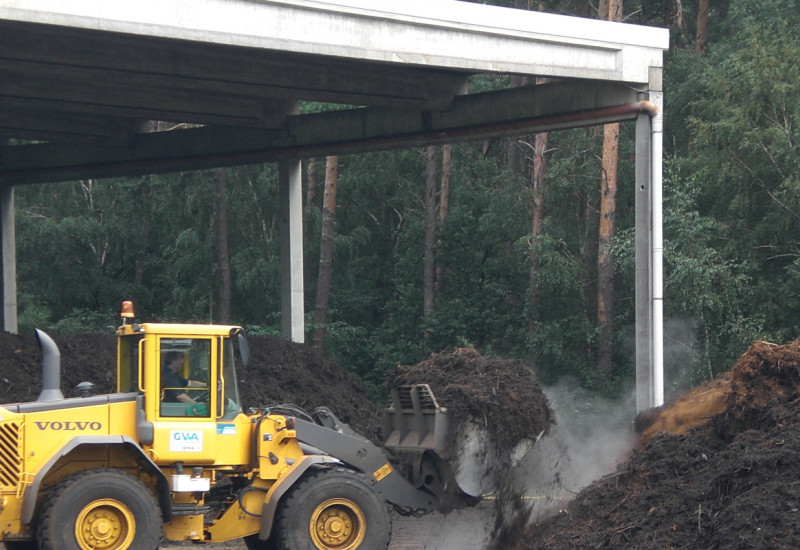 A yellow wheel loader implements composting in a composting plant.