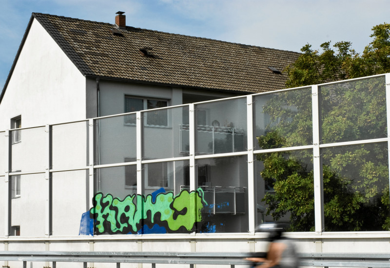 Ein grauer Hauseingang mit einer Bushaltestelle
